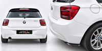 Load image into Gallery viewer, White BMW 1 Series hatchback shown from the rear and rear three-quarter angle, featuring a black rear spoiler and a black rear diffuser with an 'STM STYLING' license plate frame.
