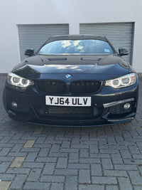 Load image into Gallery viewer, A black BMW F36 Gran coupe parked on a gray paved driveway in front of a white garage door.
